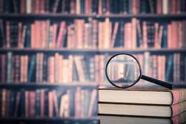 magnifying glass on top of a stack of books